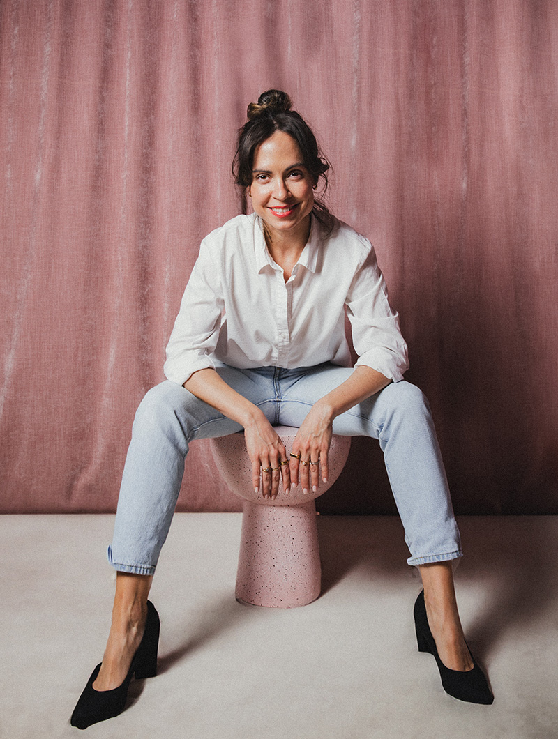 Pengar föreläsaren Ellie Elmondt poserar framför en rosa gardin